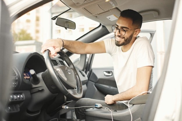 Imagem mostra homem jovem em seu carro ideal